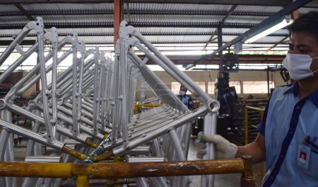 Téléchargez les photos : SIDOARJO, INDONESIA - APRIL 9, 2015: Worker checking on the assembly line at the assembly bicycle from Indonesia Polygon in Sidoarjo, East Java, Indonesia - en image libre de droit
