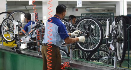 Foto de SIDOARJO, INDONESIA - APRIL 9, 2015: Workers check on the assembly line at the assembly bicycle from Indonesia Polygon in Sidoarjo, East Java, Indonesia - Imagen libre de derechos