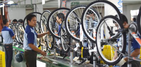 Téléchargez les photos : SIDOARJO, INDONESIA - APRIL 9, 2015: Workers check on the assembly line at the assembly bicycle from Indonesia Polygon in Sidoarjo, East Java, Indonesia - en image libre de droit