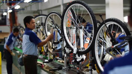 Téléchargez les photos : SIDOARJO, INDONÉSIE - 9 AVRIL 2015 : Les travailleurs vérifient la chaîne de montage du vélo d'assemblage de Indonesia Polygon à Sidoarjo, Java Est, Indonésie - en image libre de droit