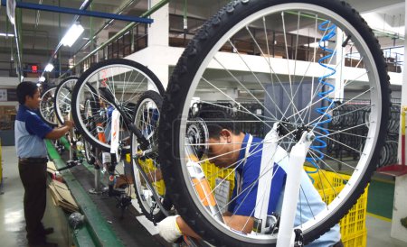 Téléchargez les photos : SIDOARJO, INDONÉSIE - 9 AVRIL 2015 : Les travailleurs vérifient la chaîne de montage du vélo d'assemblage de Indonesia Polygon à Sidoarjo, Java Est, Indonésie - en image libre de droit