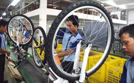Foto de SIDOARJO, INDONESIA - 9 DE ABRIL DE 2015: Los trabajadores revisan la línea de montaje de la bicicleta de montaje del polígono de Indonesia en Sidoarjo, Java Oriental, Indonesia - Imagen libre de derechos
