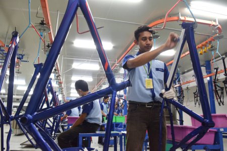 Foto de SIDOARJO, INDONESIA - 9 DE ABRIL DE 2015: Los trabajadores revisan la línea de montaje de la bicicleta de montaje del polígono de Indonesia en Sidoarjo, Java Oriental, Indonesia - Imagen libre de derechos