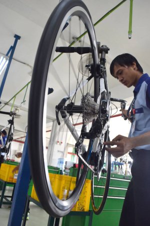 Foto de SIDOARJO, INDONESIA - APRIL 9, 2015: Worker checking on the assembly line at the assembly bicycle from Indonesia Polygon in Sidoarjo, East Java, Indonesia - Imagen libre de derechos