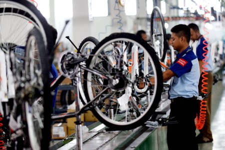 Photo for SIDOARJO, INDONESIA - APRIL 9, 2015: Workers check on the assembly line at the assembly bicycle from Indonesia Polygon in Sidoarjo, East Java, Indonesia - Royalty Free Image