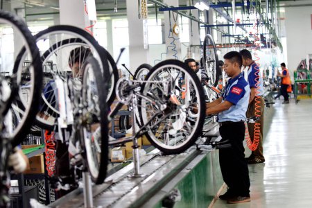 Photo for SIDOARJO, INDONESIA - APRIL 9, 2015: Workers check on the assembly line at the assembly bicycle from Indonesia Polygon in Sidoarjo, East Java, Indonesia - Royalty Free Image