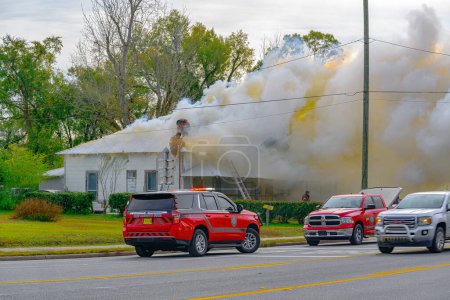 Photo for Youngstown, Florida, United States December 20, 2023. Amid a chaotic house fire, a team of courageous firefighters is engaged in a high-stakes battle against the relentless blaze. - Royalty Free Image