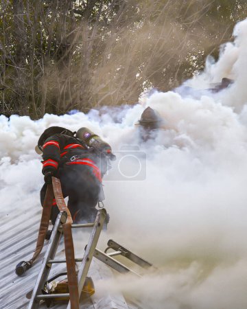 Photo for Youngstown, Florida, United States December 20, 2023. Amid a chaotic house fire, a team of courageous firefighters is engaged in a high-stakes battle against the relentless blaze. EDITORIAL USE ONLY - Royalty Free Image