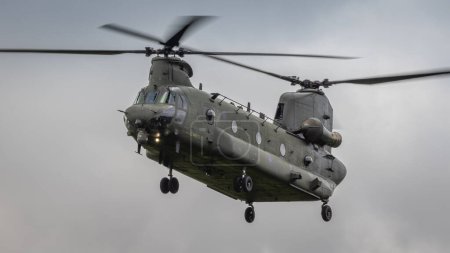 Photo for Cosford, UK - 12th June 2022: A Boeing Chinook military helicopter of the RAF hovers close to the ground - Royalty Free Image