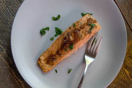 Vue latérale du dîner de saumon avec sauce au beurre à l'ail anchois