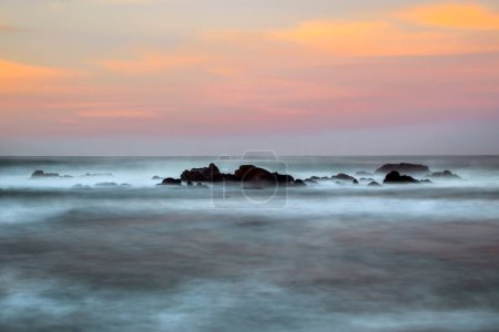 Wellen krachen bei Sonnenuntergang in der Nähe von San Simeon, Kalifornien, an der Küste entlang.