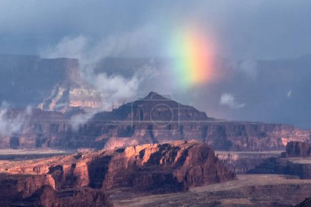 Un arc-en-ciel partiel apparaît lors d'une tempête de pluie au parc national de Canyonlands, Utah, vu du belvédère du sentier Shafer.