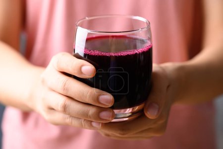 Frischer Rote-Bete-Saft im Glas mit Frauenhand, Gesundes Getränk