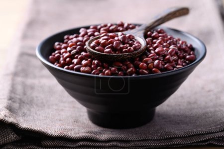 Red mung bean or Azuki bean in black bowl with spoon, Food ingredients