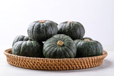 Green pumpkin or Japanese pumpkin in natural basket on white background, Vegetable in autumn season