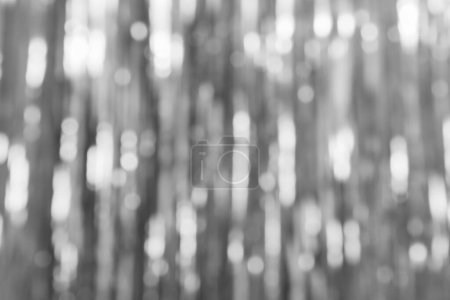 Graue Folienstreifen verschwimmen abstrakten Hintergrund mit Bokeh-Licht. Vorhang auf an der Wand. Festlich, Weihnachten, Neujahr oder Jubiläum Party-Konzept. Dekorative Tapeten