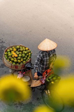 Foto de Hanoi, Vietnam - 08 de mayo de 2023: Personas, vendedores, bicicletas y conductores de ciclomotores que llevan al turista a una calle concurrida y bulliciosa en el casco antiguo de Hanoi, en el norte de Vietnam. Famoso destino de Vietnam - Imagen libre de derechos