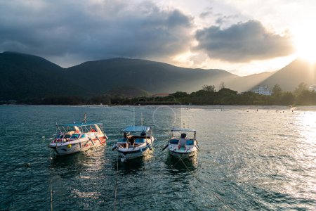 Téléchargez les photos : Une île paisible de Con Dao, le Vietnam est un paradis insulaire vietnamien. Vue côtière avec vagues, littoral, ciel clair et route, mer bleue, touristes et montagne. Concept de voyage et paysage. - en image libre de droit