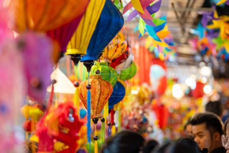 Photo for Decorated colorful lanterns hanging on a stand in the streets in Ho Chi Minh City, Vietnam during Mid Autumn Festival. Chinese language in photos mean money and happiness. Selective focus. - Royalty Free Image