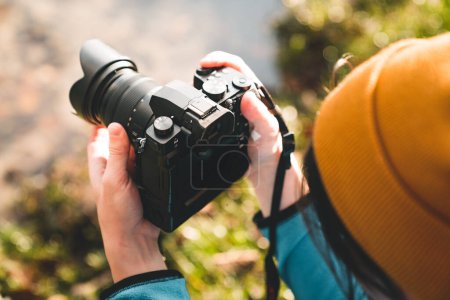 Photo for Outdoor photographer taking landscape photos using digital camera. Side view of man using dsrl outdoors in bright light - Royalty Free Image