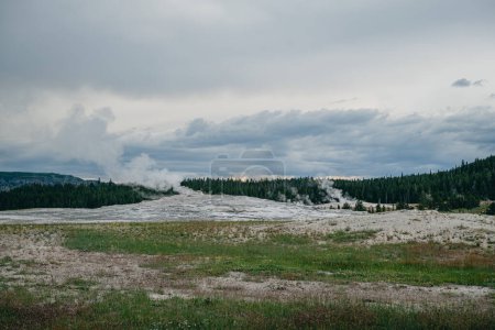 Foto de Vapor saliendo del viejo géiser fiel bajo un cielo nublado al atardecer en el Parque Nacional de Yellowstone - Imagen libre de derechos