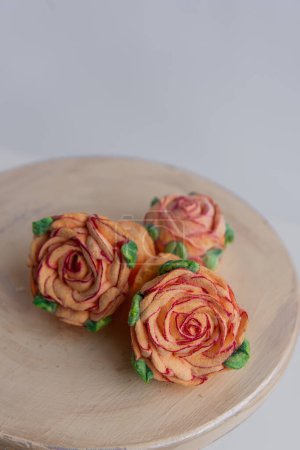 Photo for On a wooden round background lie natural orange marshmallows in the form of roses flowers. Sweet desserts without sugar. Creative baking confectioners. Copy space, mock up. Sweet food - Royalty Free Image