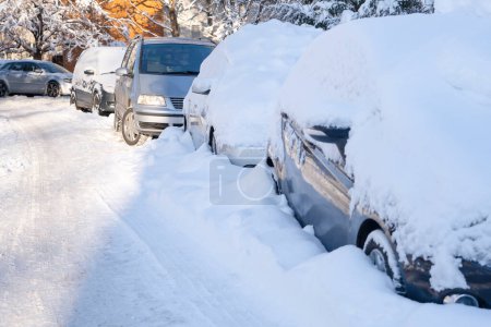 Téléchargez les photos : Rangée de voitures recouvertes de neige garées en file. Journée ensoleillée en extérieur - en image libre de droit