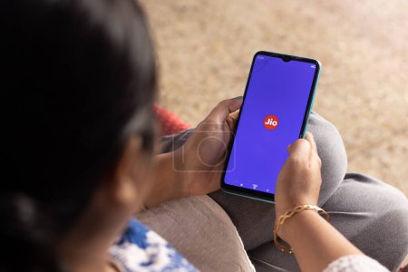 Photo for Birbhum, West Bengal, India - December 27th 2022: An Indian woman with smart phone using Reliance Jio application at home - Royalty Free Image