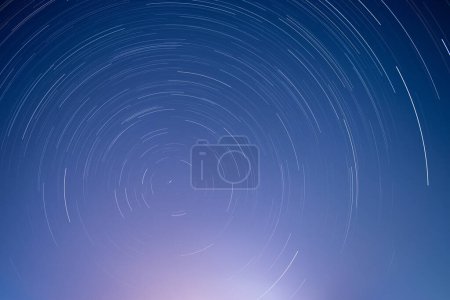 Photo for Star trails in blue starry night sky - Royalty Free Image