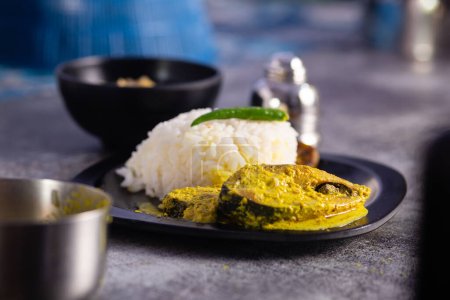 Photo for Hilsa fish curry with mustard paste and green chilli served on plate along side rice with selective focus - Royalty Free Image