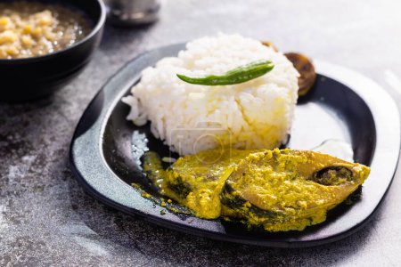 Photo for Hilsa fish curry with mustard paste and green chilli served on plate along side rice with selective focus - Royalty Free Image