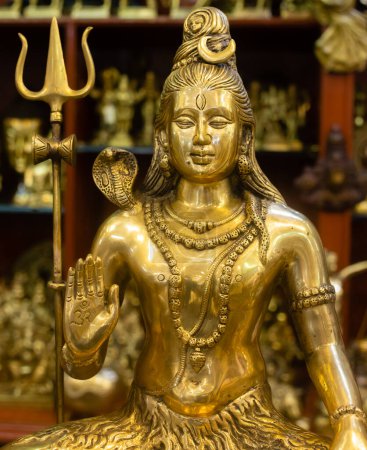 Brass idol of lord Shiva along with other statues being sold at an Indian market shop
