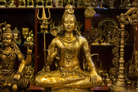 Brass idol of lord Shiva along with other statues being sold at an Indian market shop