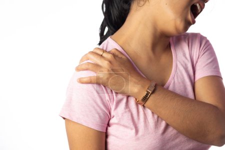 An Indian woman holding her shoulder for pain showing painful expression on white background