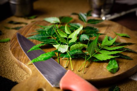Raw green neem leaves on a chopping board