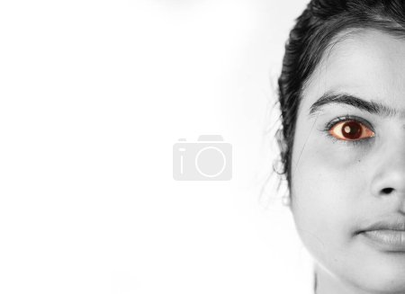 Nahaufnahme monochromer Ansicht des gelben rötlichen Auges einer indischen Frau, Gesundheitskonzept