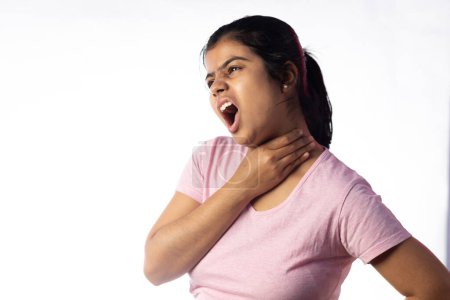 An Indian woman holding her throat showing painful expression on white background