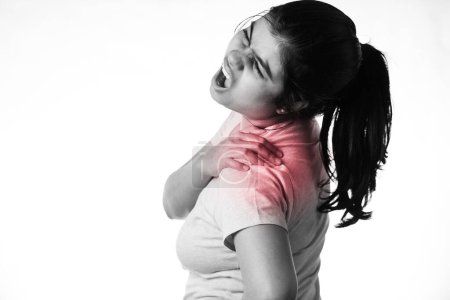 An Indian woman holding her shoulder for pain showing painful expression on white background