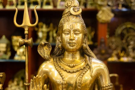 Ídolo de bronce del señor Shiva junto con otras estatuas que se venden en una tienda de mercado india