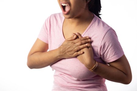 An Indian woman holding her chest for pain showing painful expression on white background