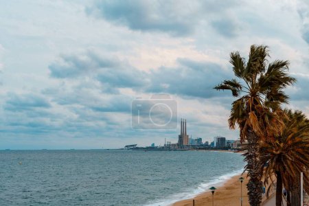 Foto de Badalona, España- 18 de septiembre de 2022. Playa Badalona, España. En el fondo termica central tres chimeneas - Imagen libre de derechos