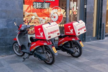 Foto de Barcelona, Spain-January 17, 2023. Delivery motorbikes of Telepizza, a Spanish multinational pizzeria chain with a presence in several countries around the world. San Sebastin de los Reyes, Madrid. - Imagen libre de derechos