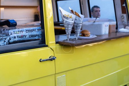 Foto de Barcelona, España-17 de febrero de 2023. Pequeña empresa en forma de camión de comida, ofreciendo deliciosa comida callejera a sus clientes. - Imagen libre de derechos