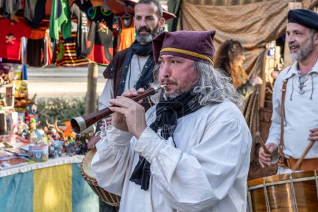 Photo for Barcelona, Spain-March 12, 2023. A musician in the street playing the gralla or dulzaina, a traditional Catalan instrument, with brightly coloured clothes and a cheerful expression. - Royalty Free Image