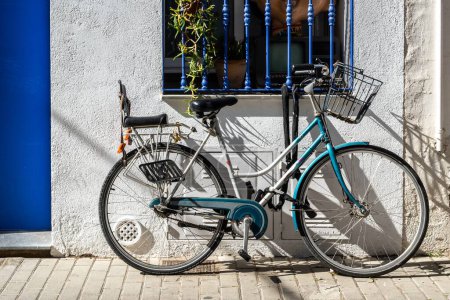 Foto de Casa del pueblo mediterráneo con bicicleta al aire libre, puertas, ventanas y exterior del edificio. - Imagen libre de derechos