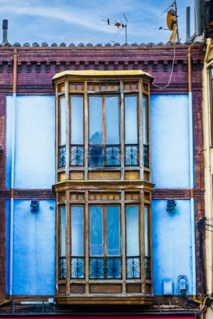 Photo for Dazzling blue building exterior with wooden balconies and elegant windows. No people. - Royalty Free Image