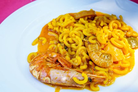 Photo for Fideu,fideuada, a dish originating in Ganda, Valencian Community, Spain that is made similarly to paella, although based on noodles instead of rice - Royalty Free Image