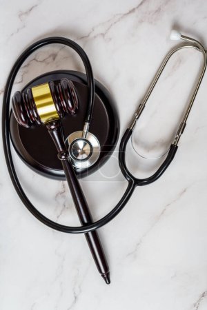 Photo for A judge's gavel and a physician's stethoscope. access and entitlement to health care regardless of race, religion, ethnicity, socioeconomic status - Royalty Free Image