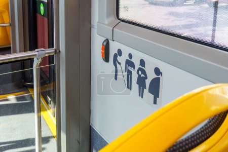 Förderung inklusiver urbaner Mobilität: Eine detaillierte Ansicht der Symbole für bevorzugte Sitzplätze in einem Stadtbus, die Barrierefreiheit und Höflichkeit für alle gewährleisten
