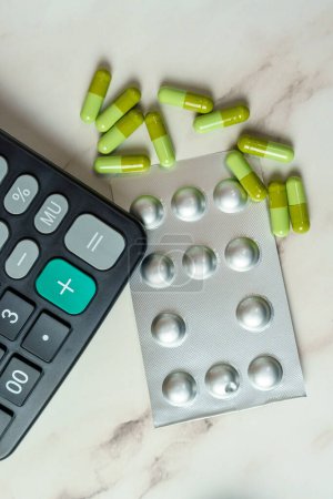 Healthcare Economics. The intersection of healthcare and personal finance, represented by green capsules and a calculator